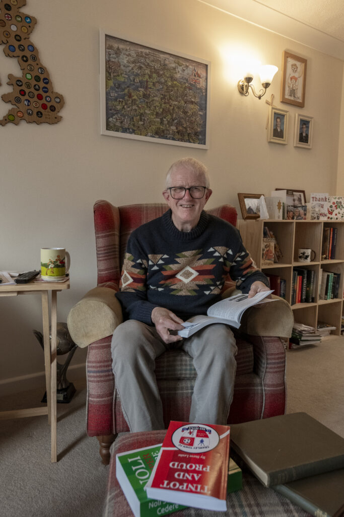 Smiling retiree in apartment with a book