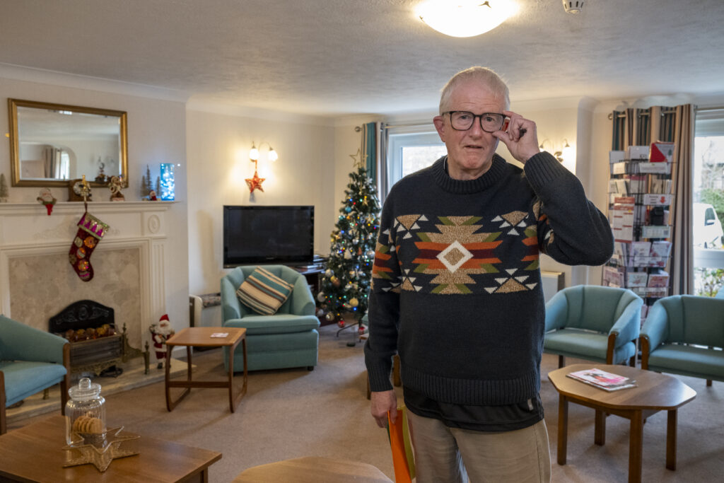 Man in communal lounge in an independent retirement living development