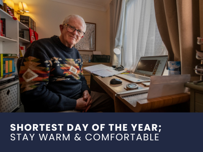 retired man in his apartment with laptop at the window